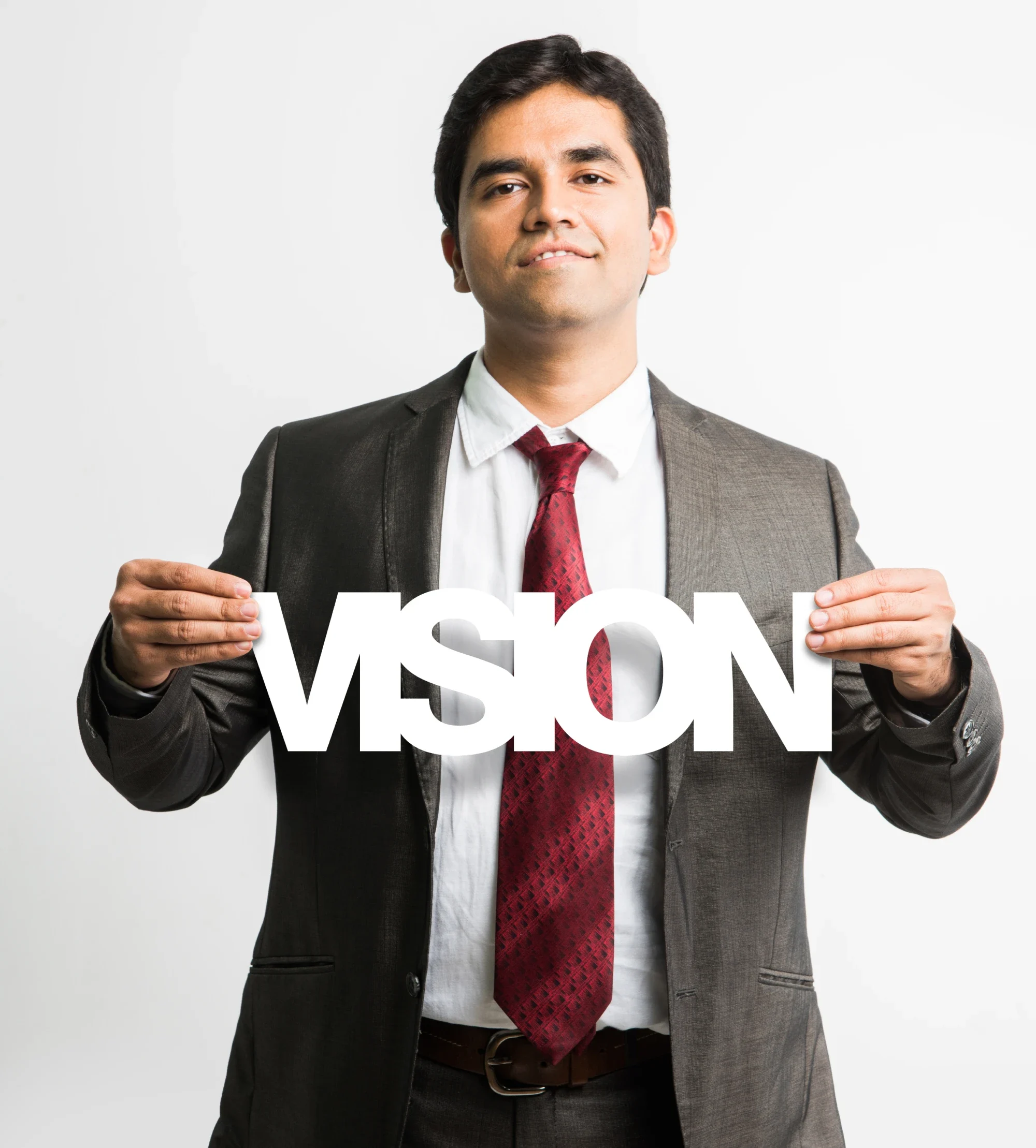 A man in a suit holds a sign reading "Vision," symbolizing clarity and future goals.